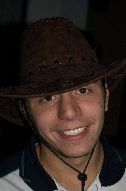 a man with a cowboy hat on smiling for a po