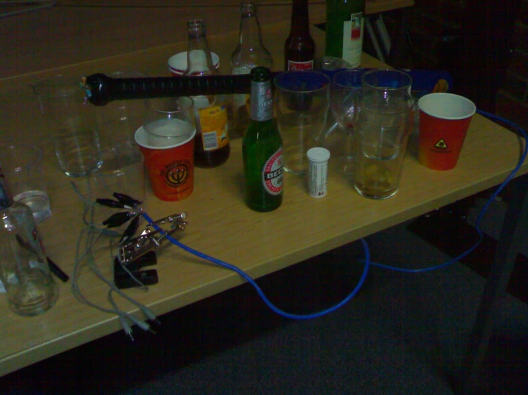several bottles sitting on top of a table covered in wires
