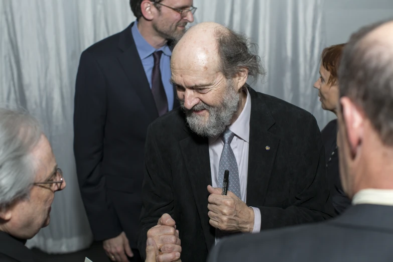 a man in suit and tie standing near other men