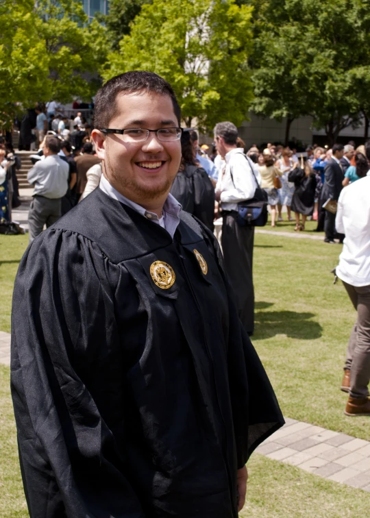 a man wearing a robe smiling in the park