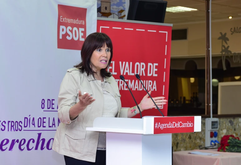 a woman standing at a podium, making a speech