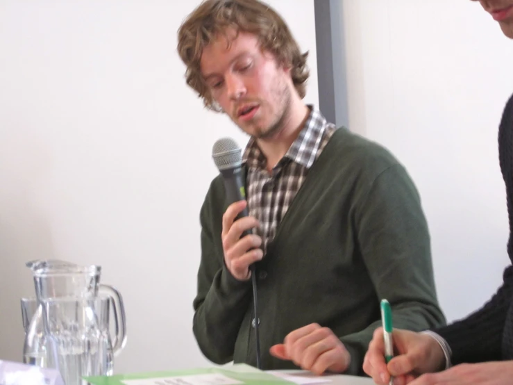 a man sitting at a table with a microphone