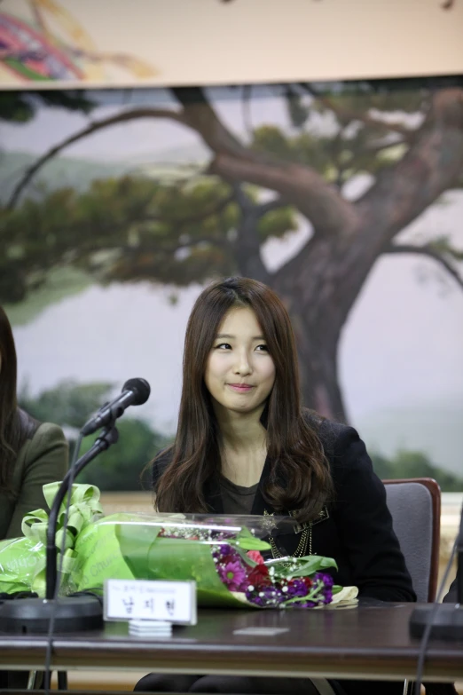 an asian women sitting in front of a microphone