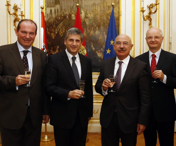 three men in suits and ties posing for a po