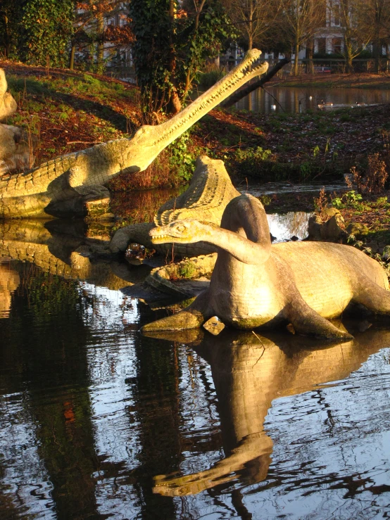 the sculpture of a cat sits on its stomach in the water