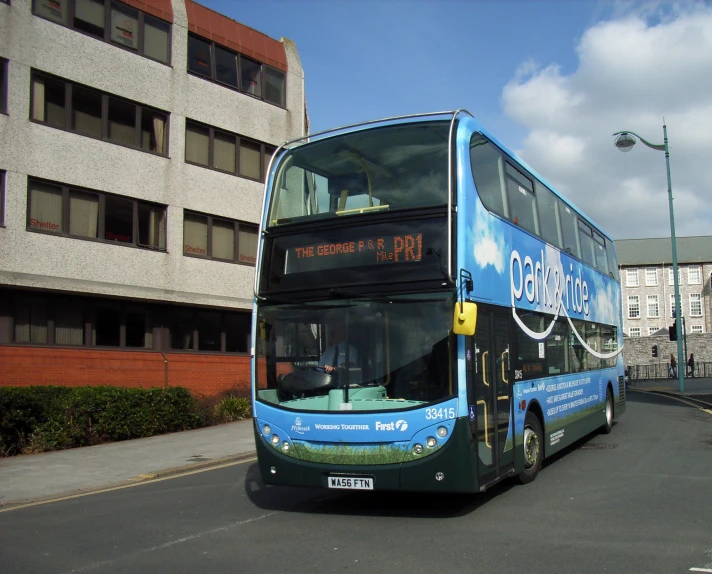 a double decker bus is on the road next to buildings