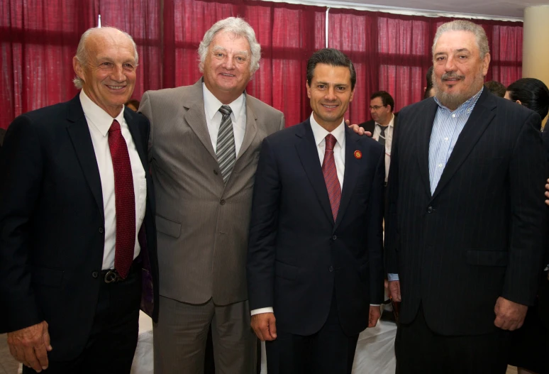 a group of men in business attire posing for a po