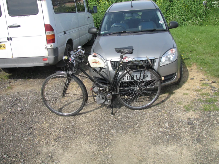 a bike sitting in the middle of a driveway with a van behind it