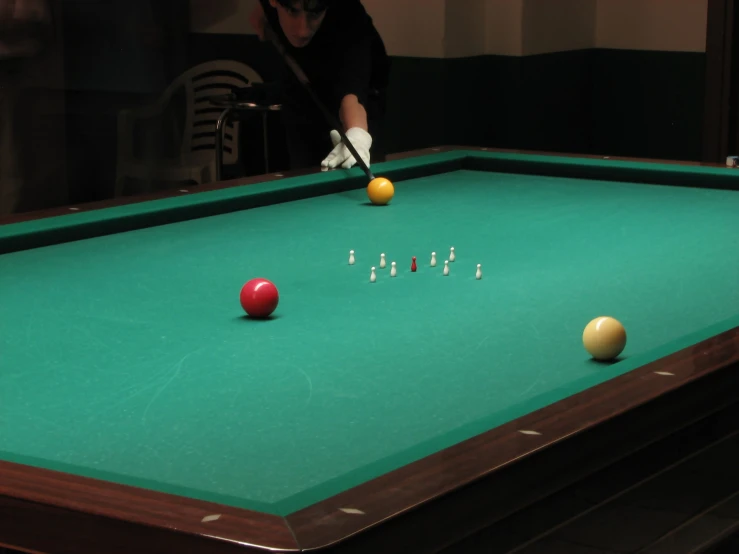 a person putting four balls in a pool