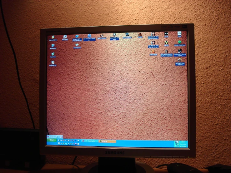 a computer monitor sitting up against a wall