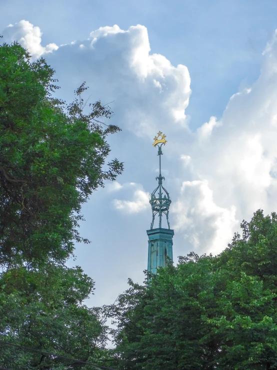 a spire atop the top of a building that has a clock displayed