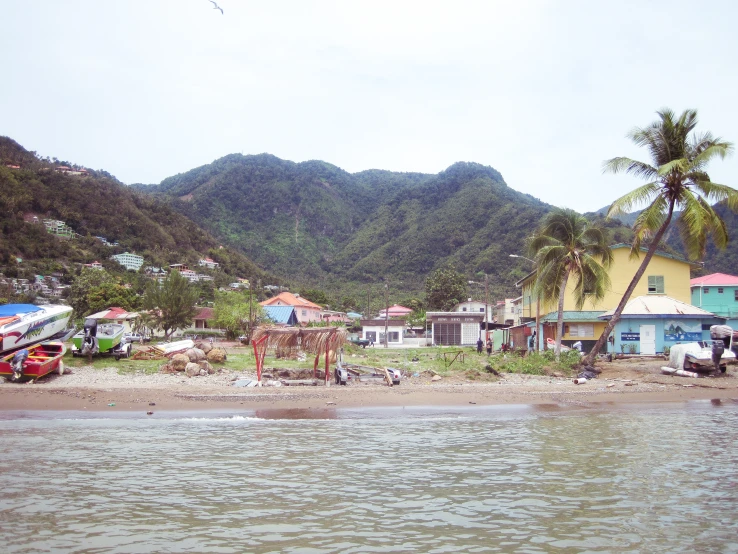 a view of a mountain side town next to the ocean