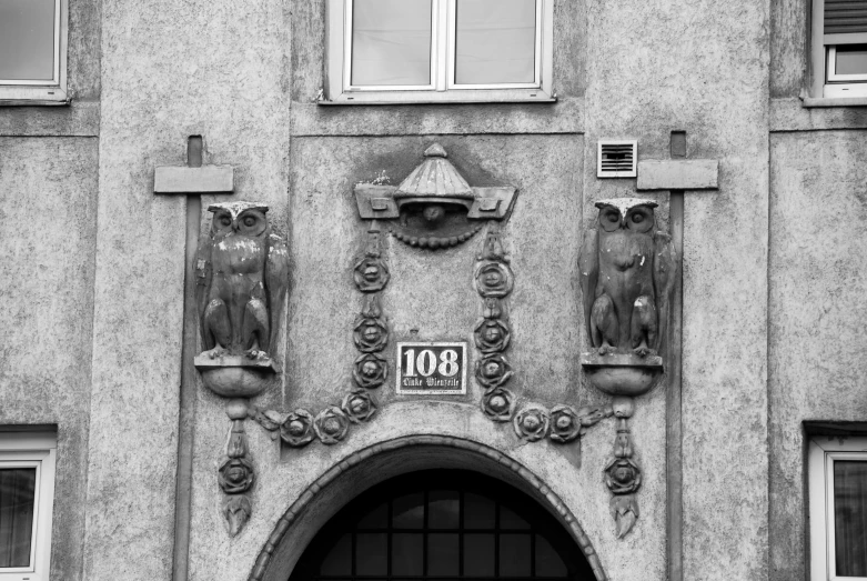 two figurines adorn the entrance of a building