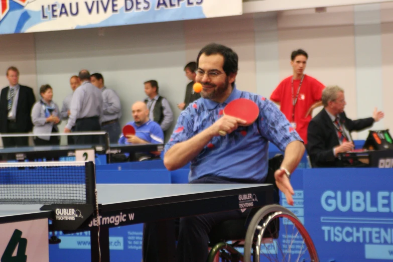 a man in a wheelchair playing ping pong