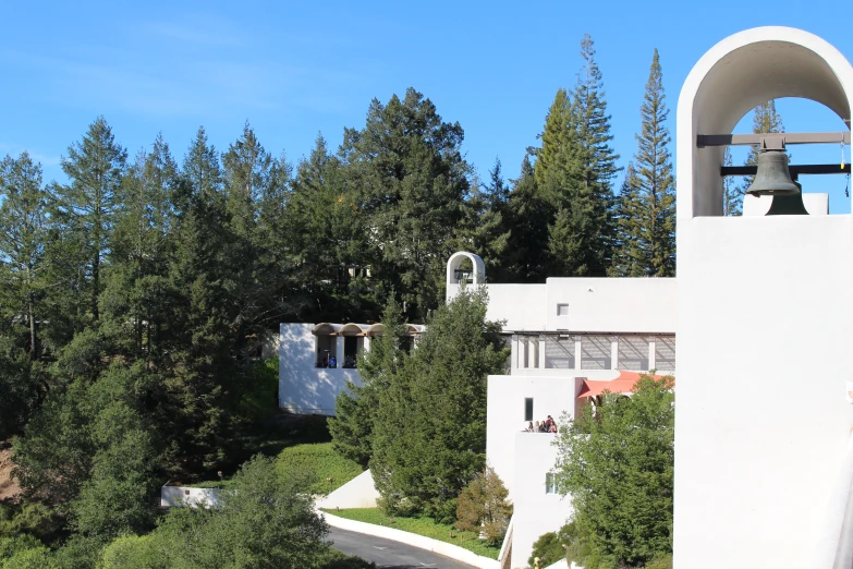 a bell in the air next to a building