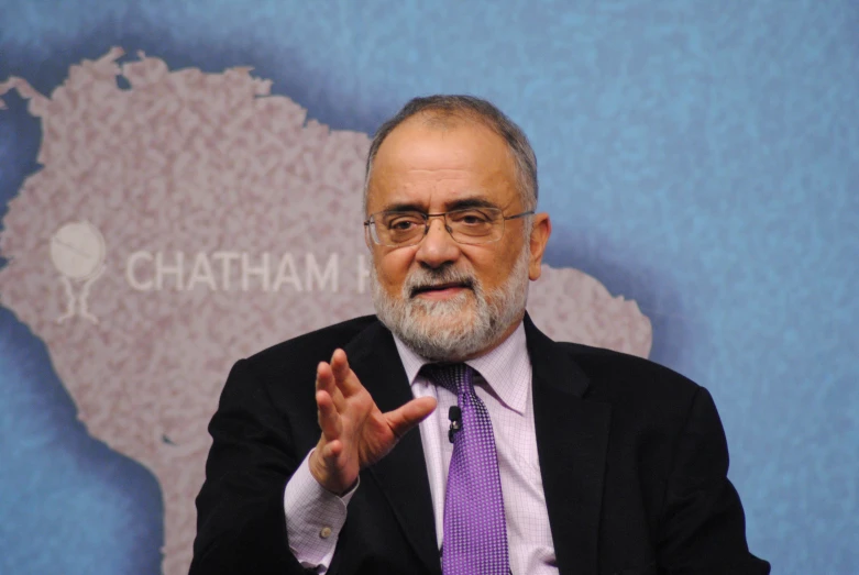 man in suit and tie gesturing to the camera