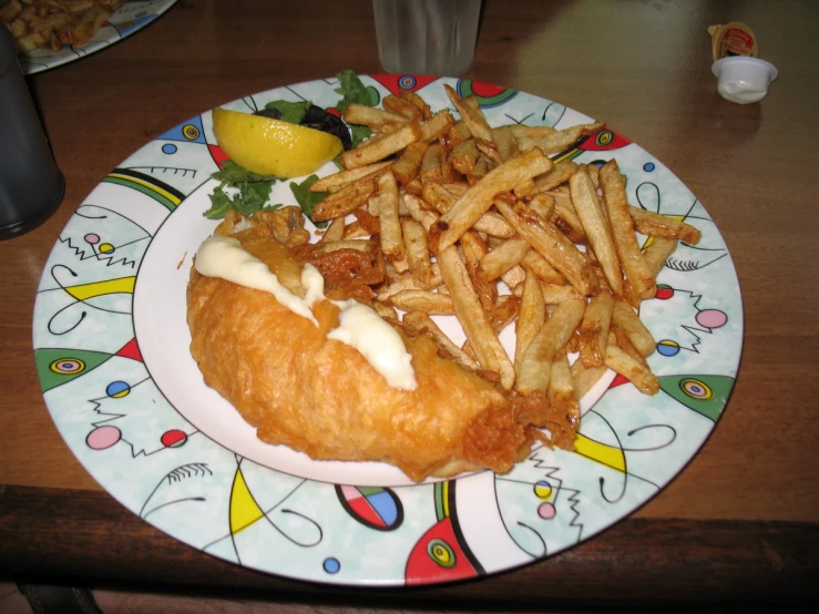 the french fries are on the plate and next to a fish and chips