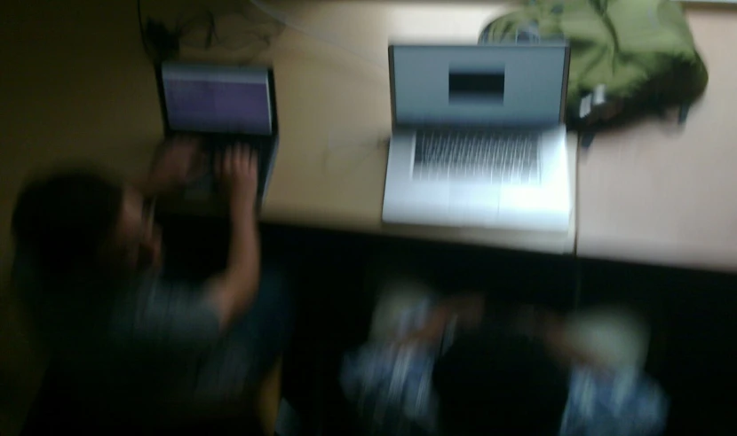 people holding up laptops that are turned on