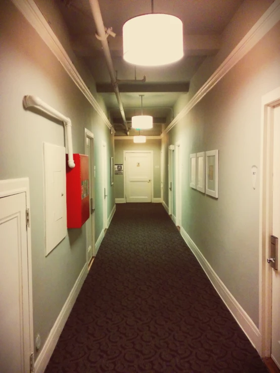 a long hallway with a few red doors