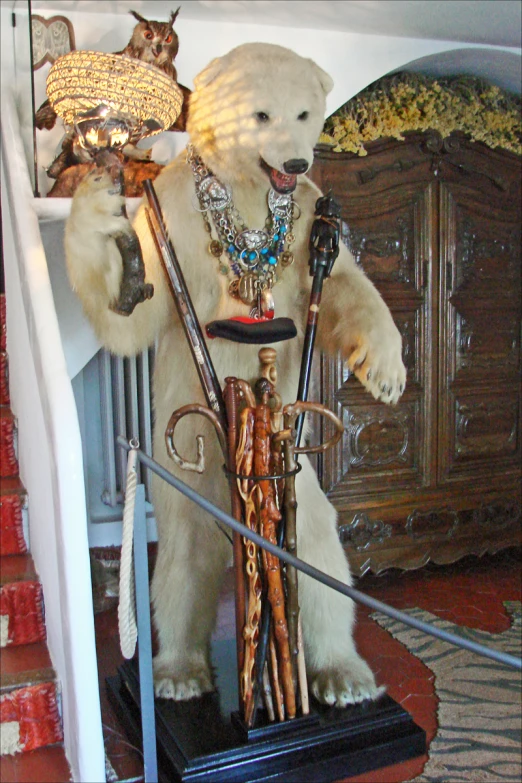 a teddy bear holding skis stands on the stairs