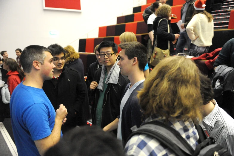 a group of young men standing around each other in a building