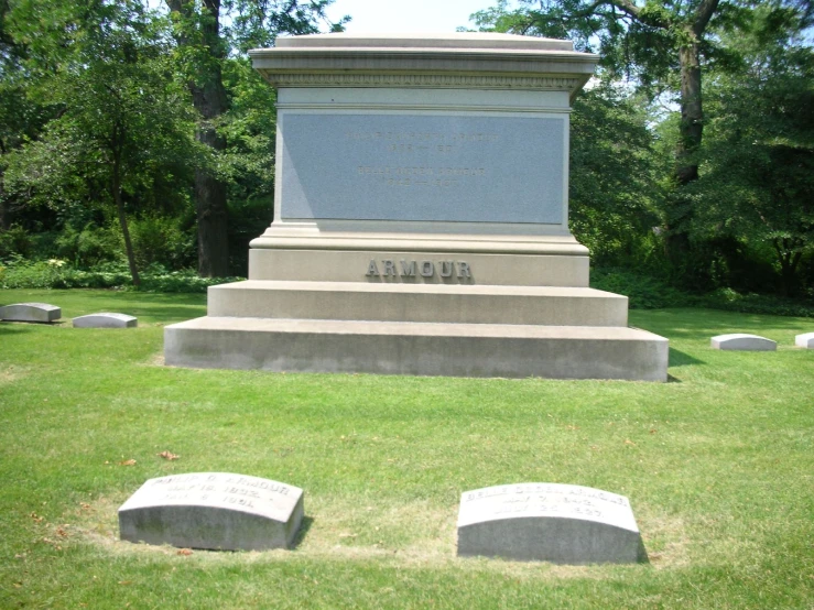 a stone monument in the middle of a lush green park