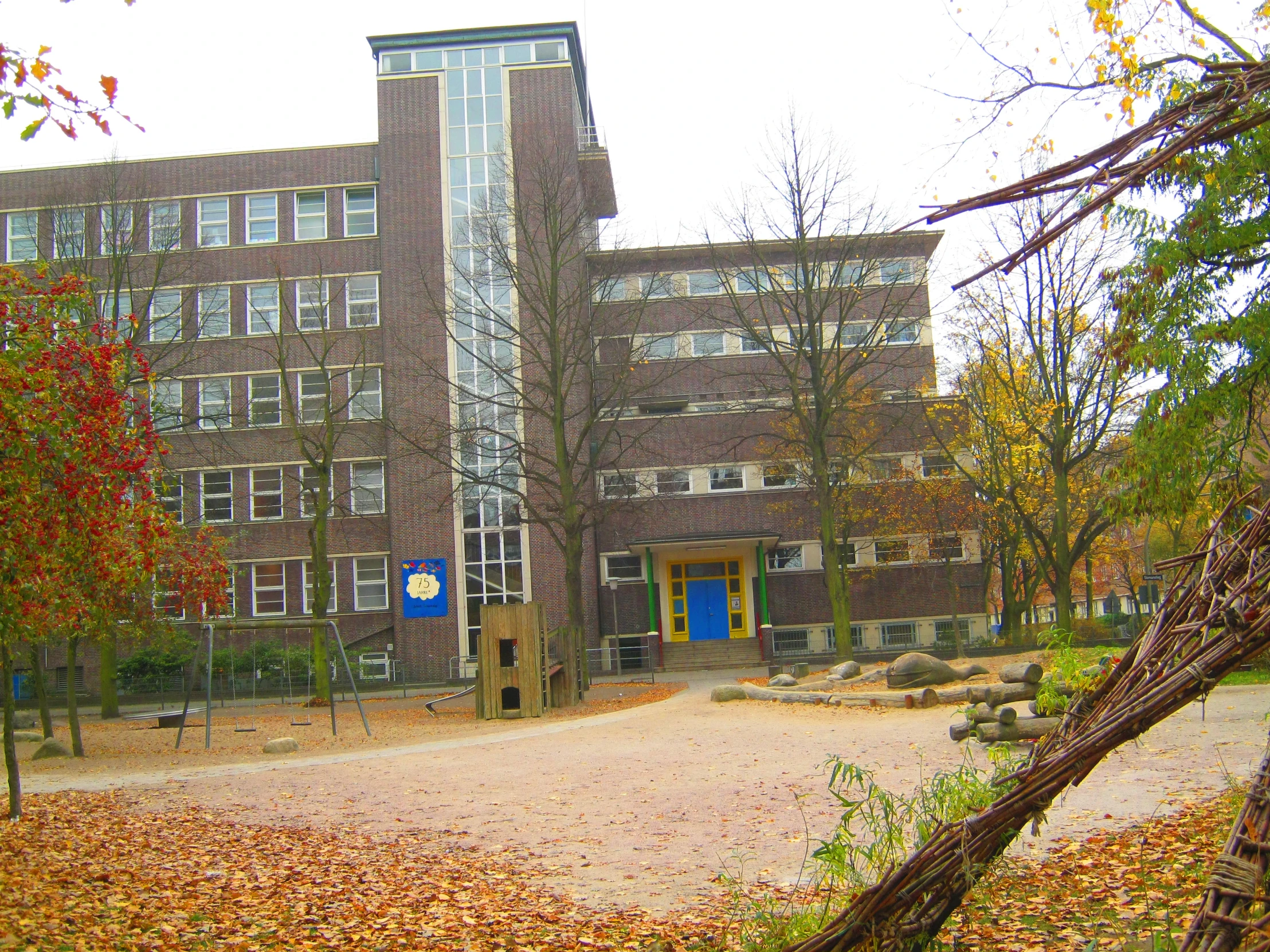 an old building with a blue door is surrounded by leaves and trees