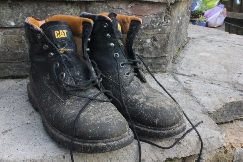 four black shoes are on some rocks