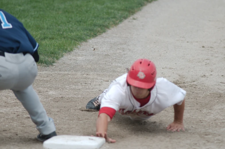 a baseball player in a red hat on the ground