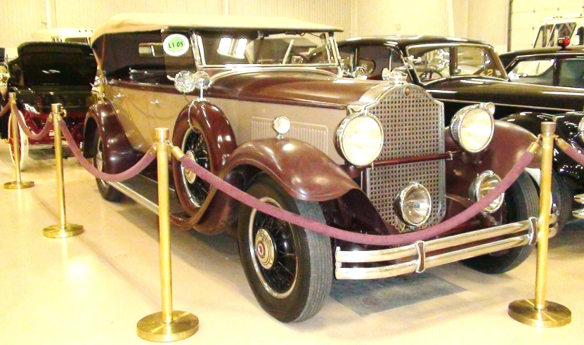 vintage cars parked inside a garage with ropes