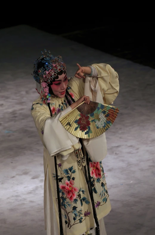 an oriental woman is dressed in white, green and gold