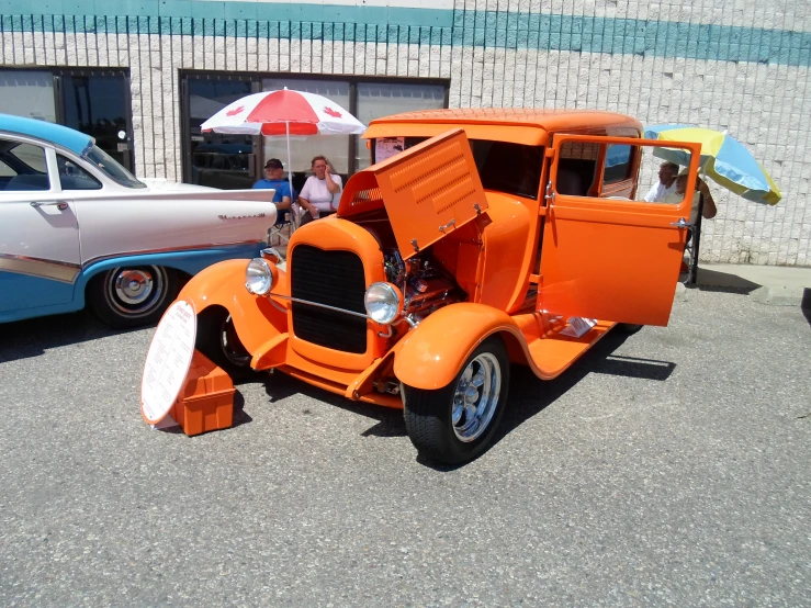 an old model orange truck parked on the side of the road