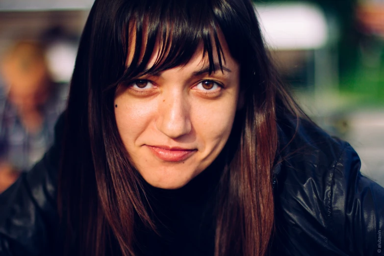 a close - up po of a woman wearing a black jacket