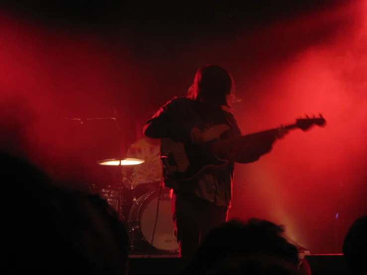 a person standing on a stage with a guitar