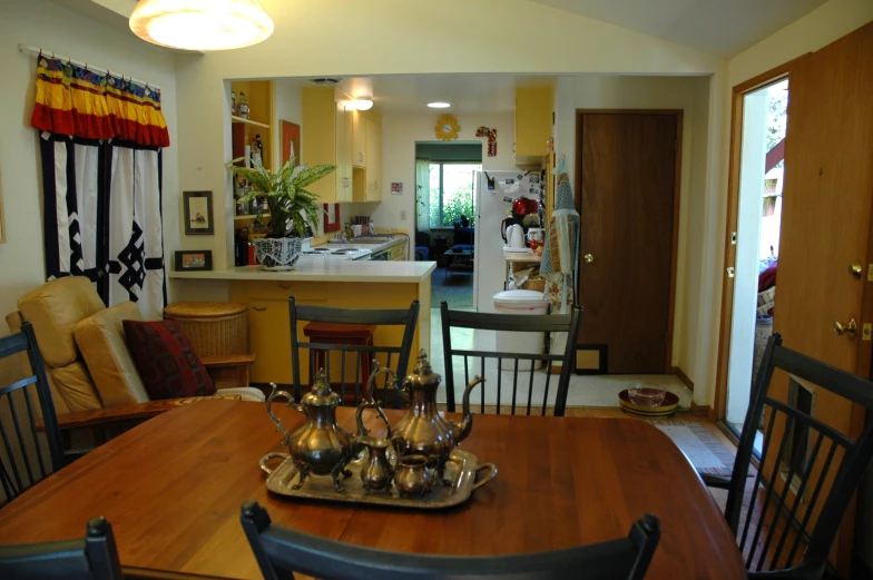 a table with silver dishes on top of it in front of a doorway