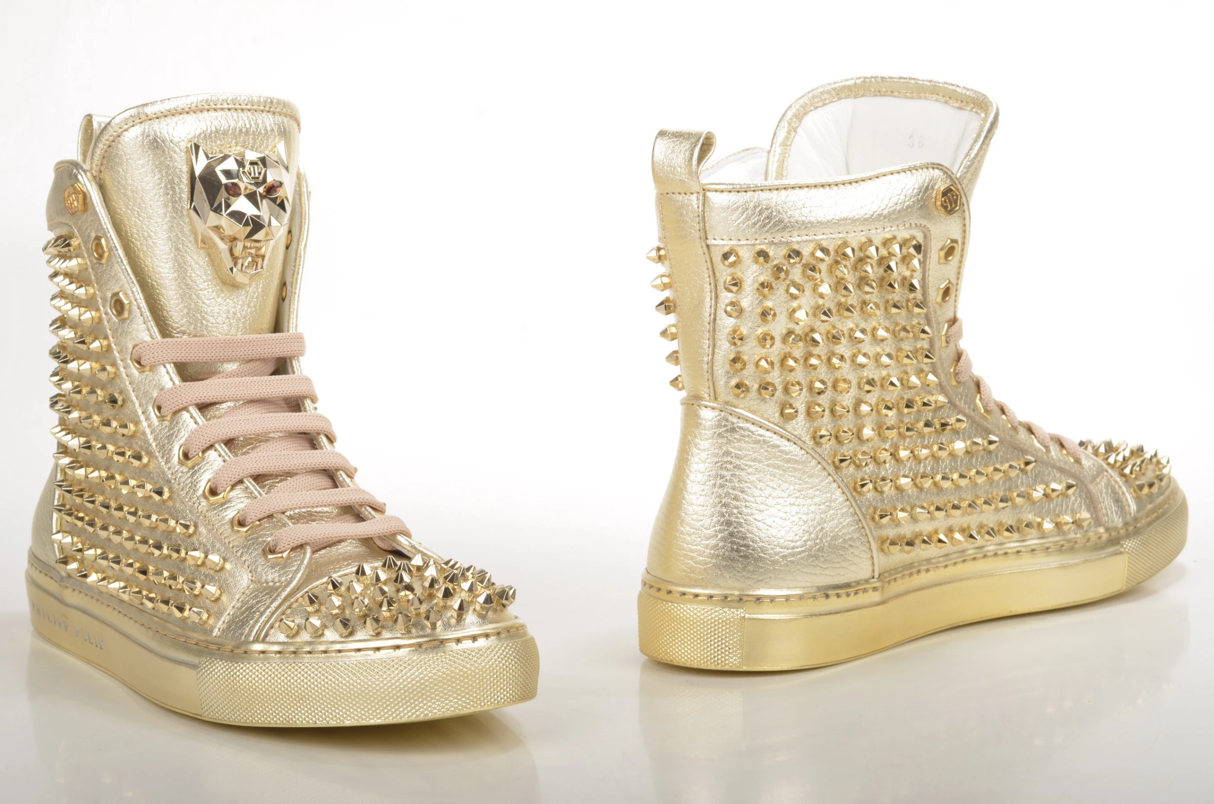 a pair of shoes with spikes in gold