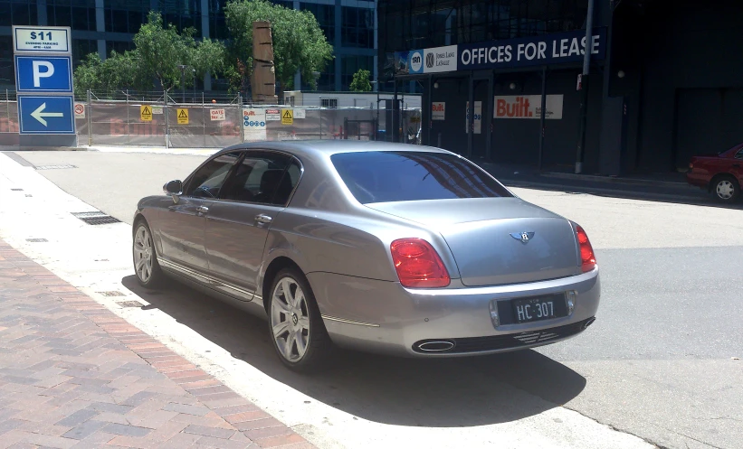 the back end of a silver car parked in a parking spot