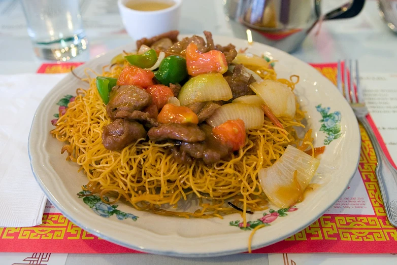 a large plate of chinese food that is covered with vegetables