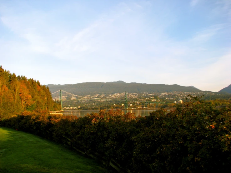 a park near the water surrounded by hills and trees