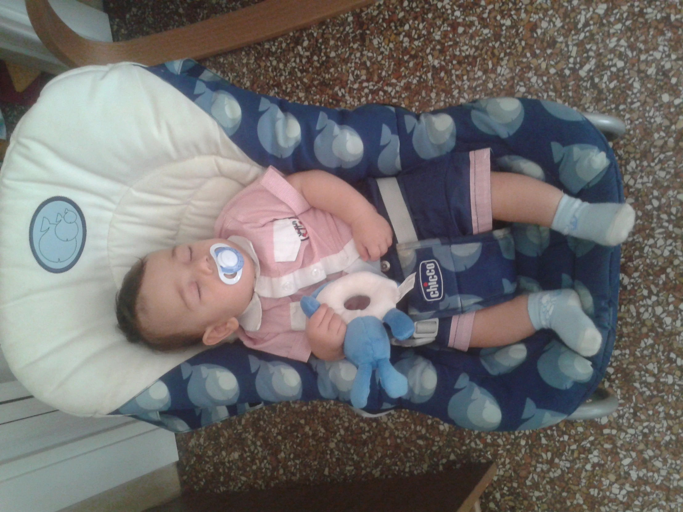 a baby laying in a highchair with a pacifier on his mouth