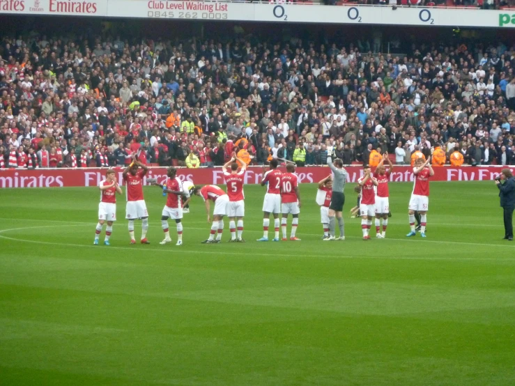 a soccer team stands at the side line for the national symbol