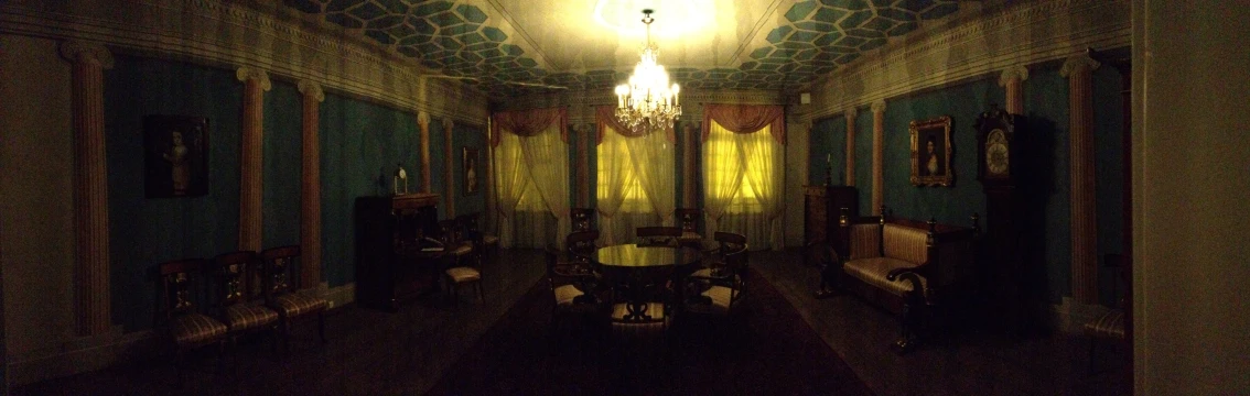 a room with blue walls, wood floors and chandelier