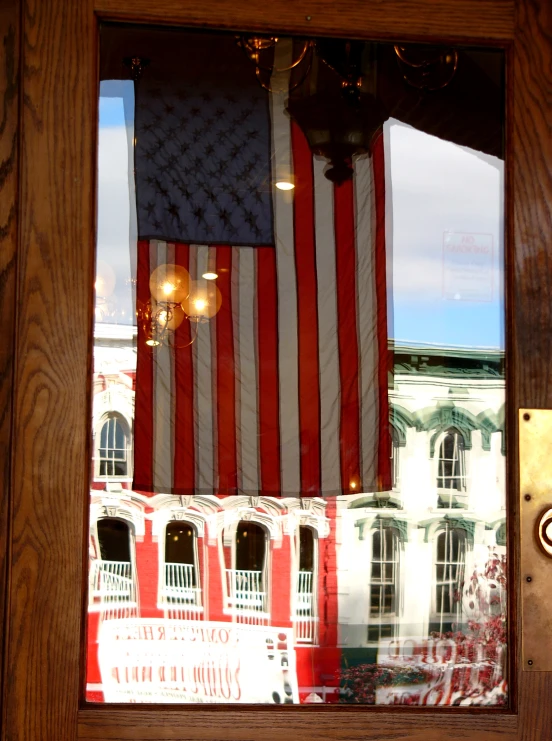 a flag reflected in a window with a clock