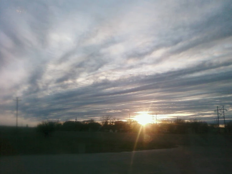 the sun is setting on an empty road