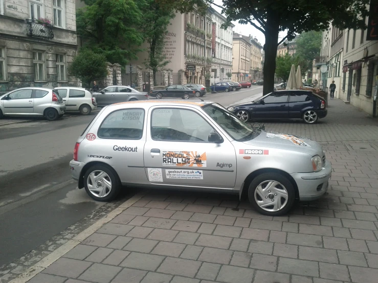 a silver car parked on a street in front of cars