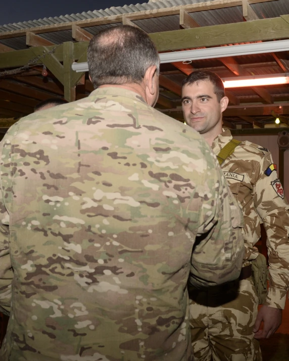 a group of men in camouflage uniforms standing together