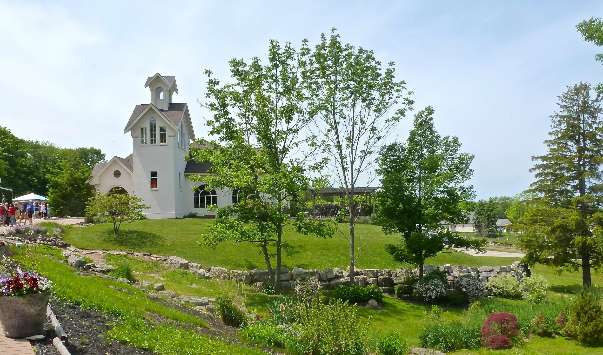 people in a garden sitting by a white church