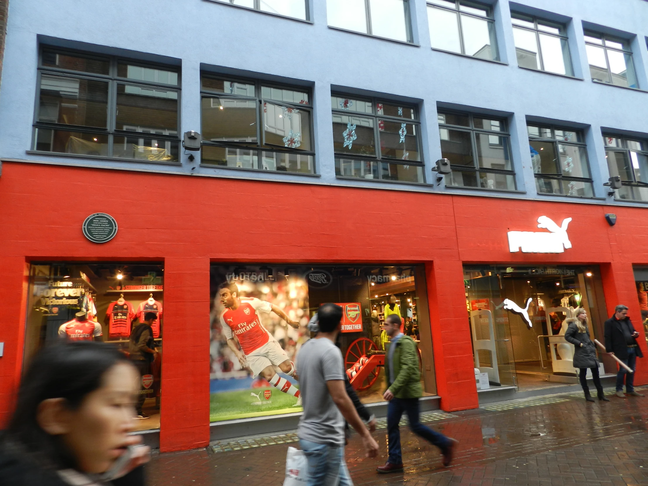 a group of people walking past shops on the street