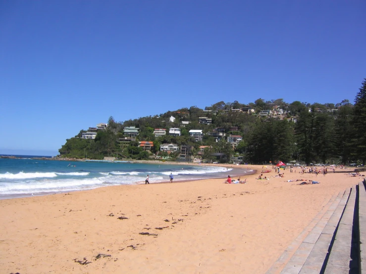 many people are laying on the beach near water