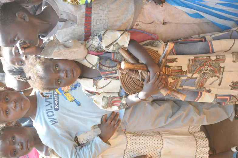 a group of children standing in a dirt lot